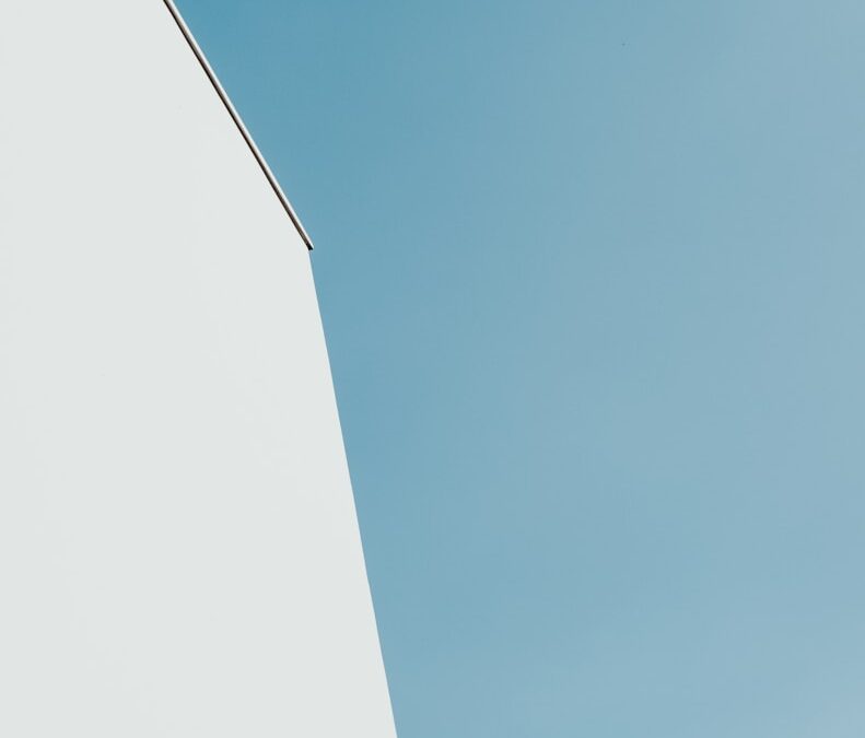 white concrete building under teal sky